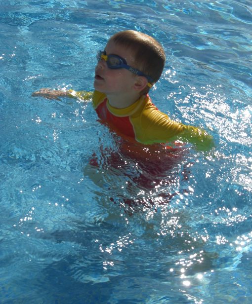 Kids long sleeve UV50+ rash vest at use in the swimming pool